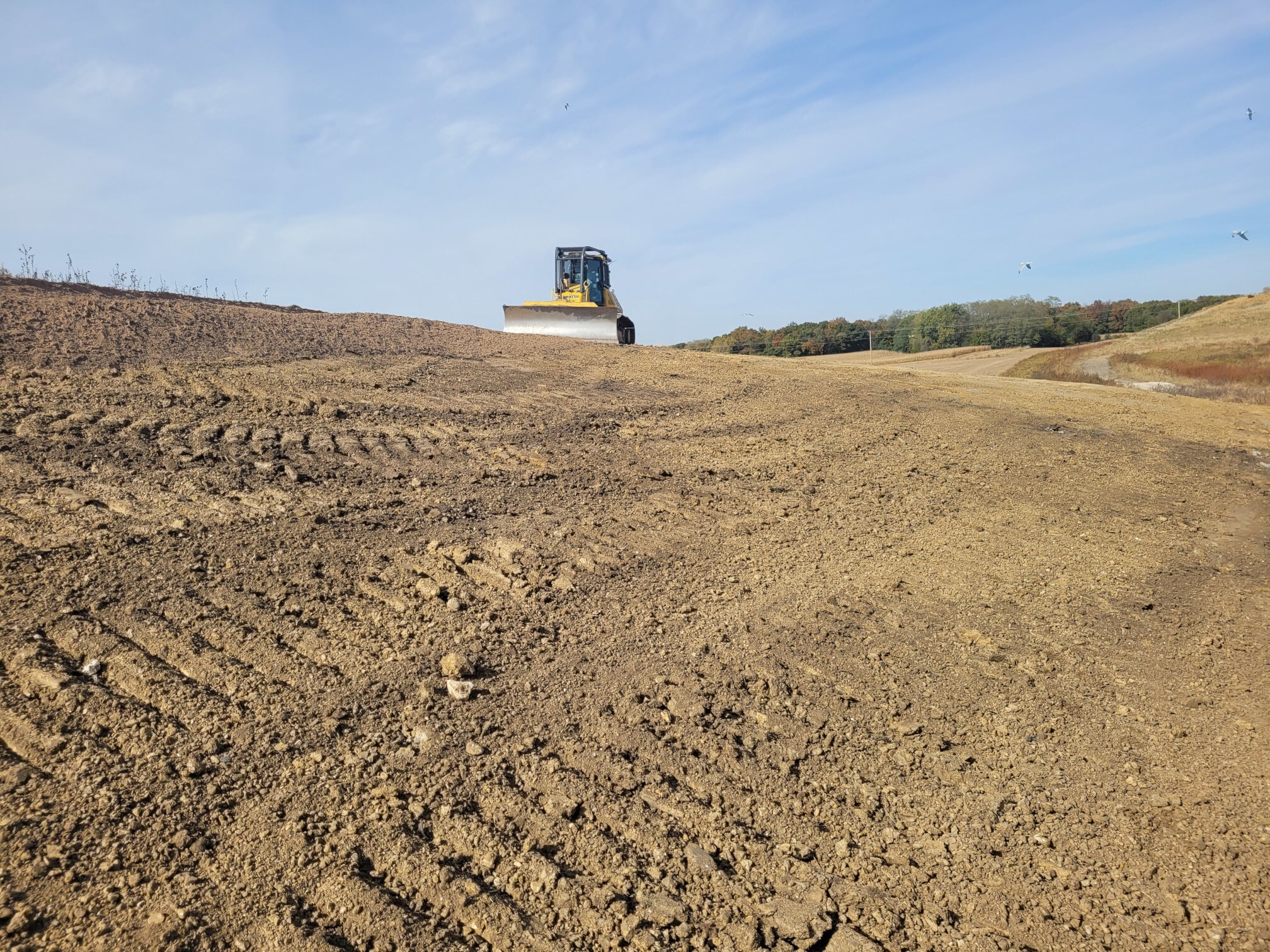 Great River Regional Waste Authority Landfill with frontloader machine tilling the land